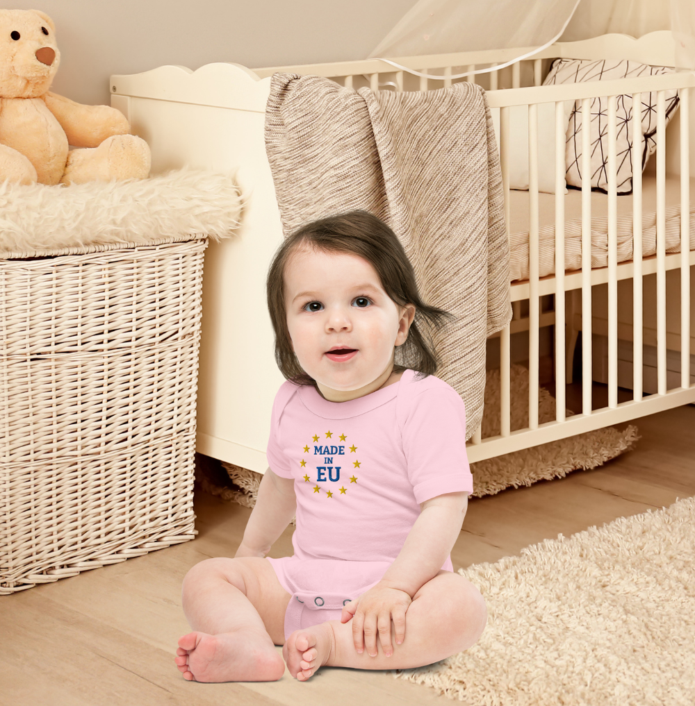 Baby wearing "Made in EU" onepiece in a nursery